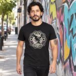Modelo con playera negra de Black Sabbath en calle con grafiti
