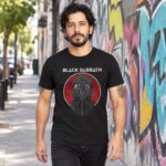 Modelo con playera negra de Black Sabbath en calle con grafiti