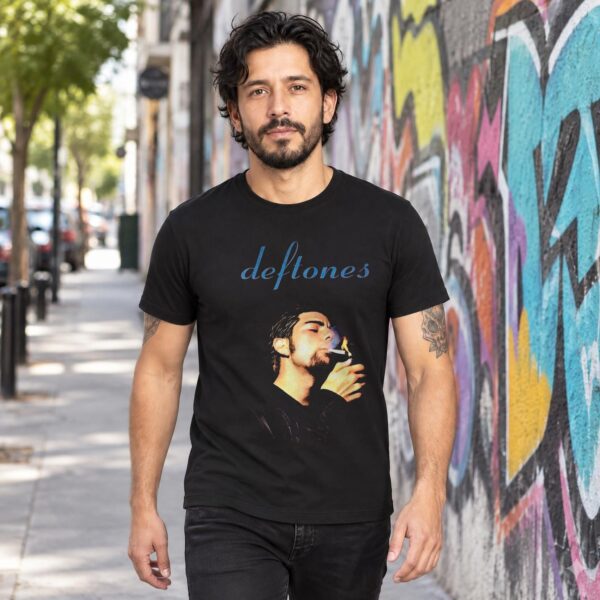 Modelo con playera negra de Deftones en calle con grafiti