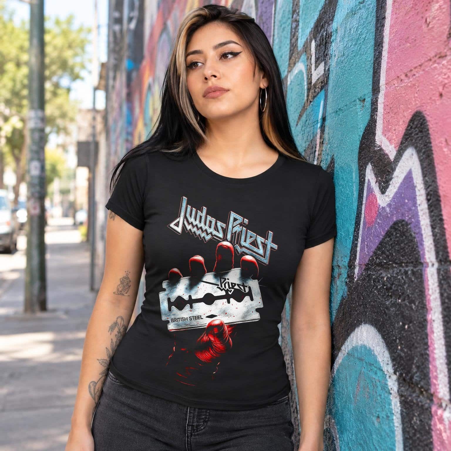Modelo con playera negra corte dama de Judas Priest en calle con grafiti