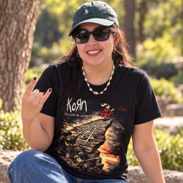 Mujer con playera negra de Korn Follow the Leader haciendo los cuernos