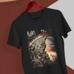 Playera negra de Korn Follow the Leader colgada en gancho rojo