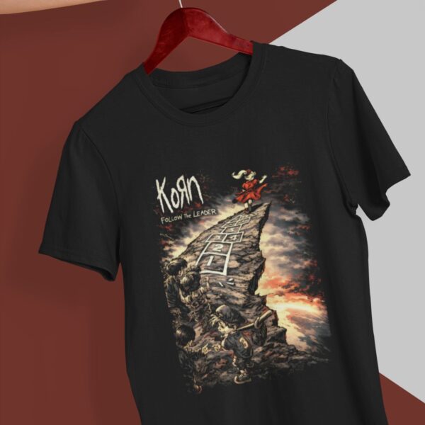 Playera negra de Korn Follow the Leader colgada en gancho rojo