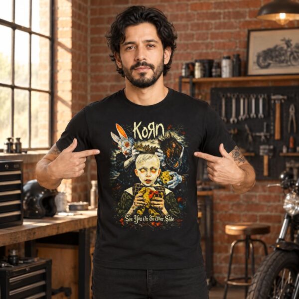 Hombre señalando su playera negra de Korn con el niño coronado y el conejo blanco