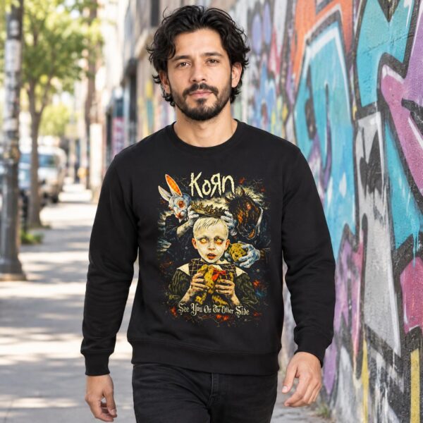 Hombre con sudadera negra de Korn See You on the Other Side caminando junto a un muro con grafiti