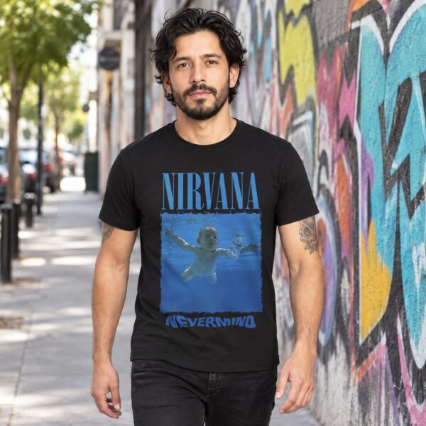 Modelo con playera negra de Nirvana en calle con grafiti