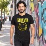 Modelo con playera negra de Nirvana en calle con grafiti