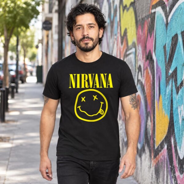 Modelo con playera negra de Nirvana en calle con grafiti