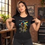 Mujer con playera negra Pink Floyd de astronautas y arcoíris señalando el estampado