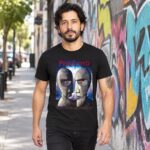 Hombre con playera negra de Pink Floyd cabezas metálicas caminando junto a un muro con grafiti