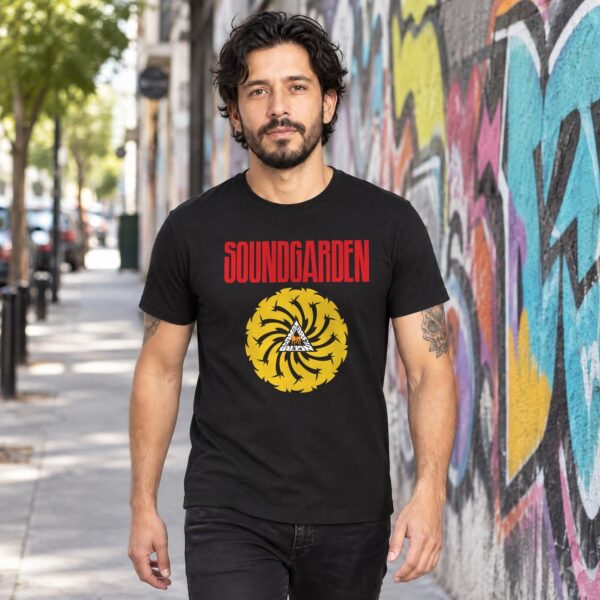 Modelo con playera negra de Soundgarden en calle con grafiti