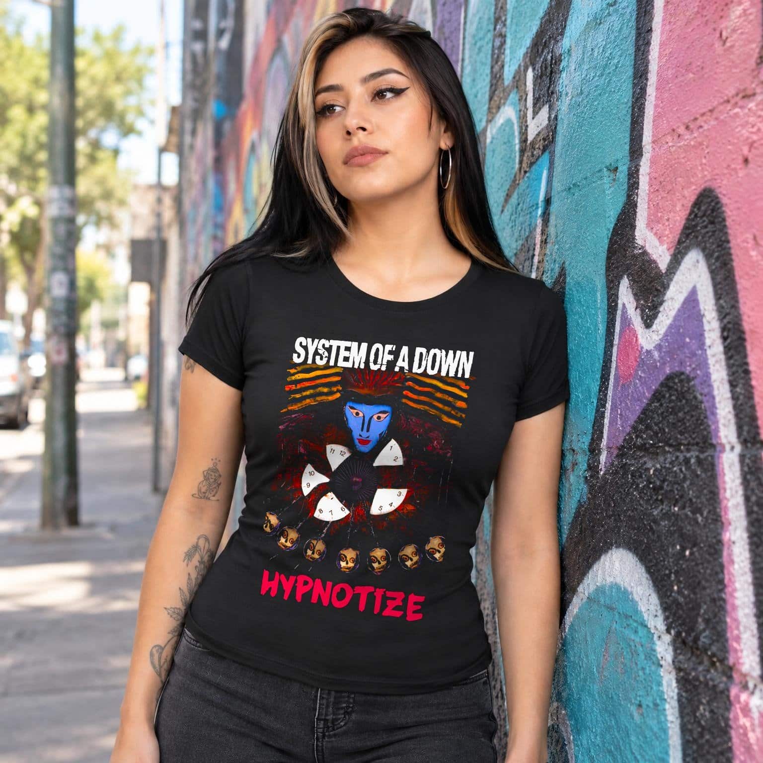 Modelo con playera negra corte dama de System of a Down en calle con grafiti