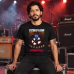 Modelo con playera negra de System of a Down en concierto