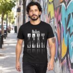Modelo con playera negra de The Beatles en calle con grafiti