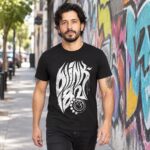 Modelo con playera negra de 3 en calle con grafiti
