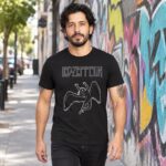 Modelo con playera negra de Led Zeppelin en calle con grafiti