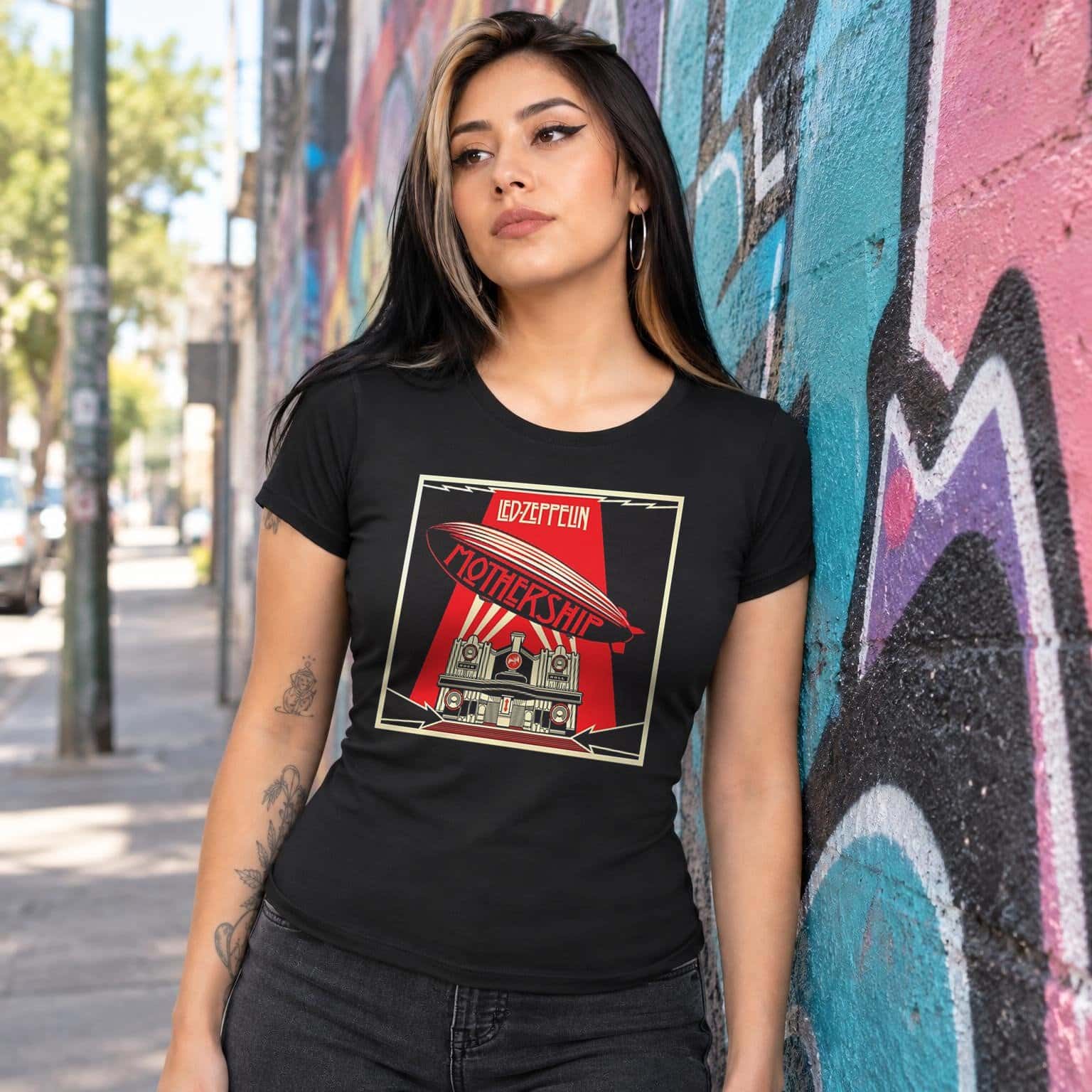 Modelo con playera negra corte dama de 3 en calle con grafiti