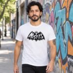 Modelo con playera blanca de 5 en calle con grafiti